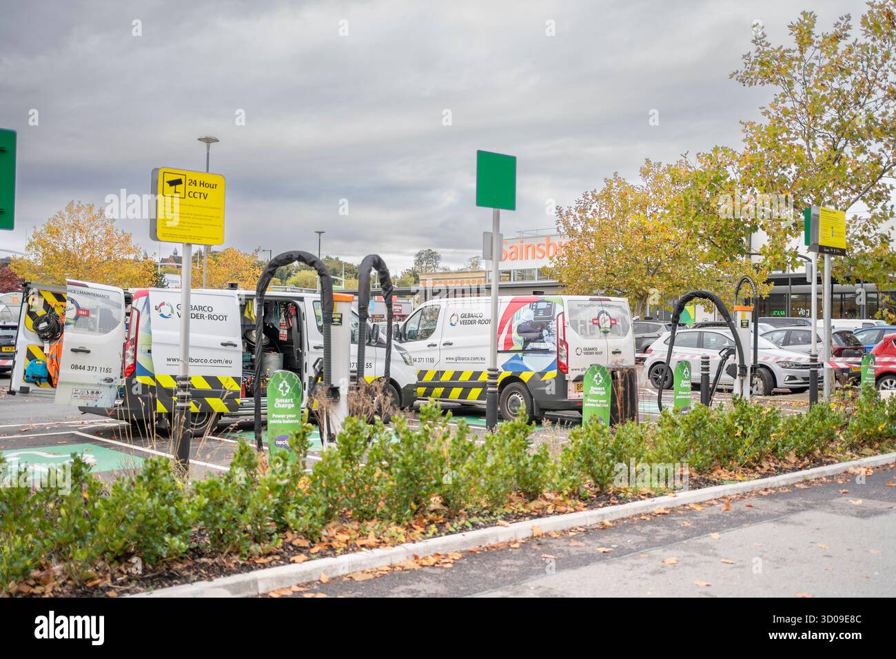 Travaux de mise à niveau et de réparation des bornes de recharge pour véhicules électriques dans un parking de supermarché Midlands Sainsbury's, Royaume-Uni. Banque D'Images
