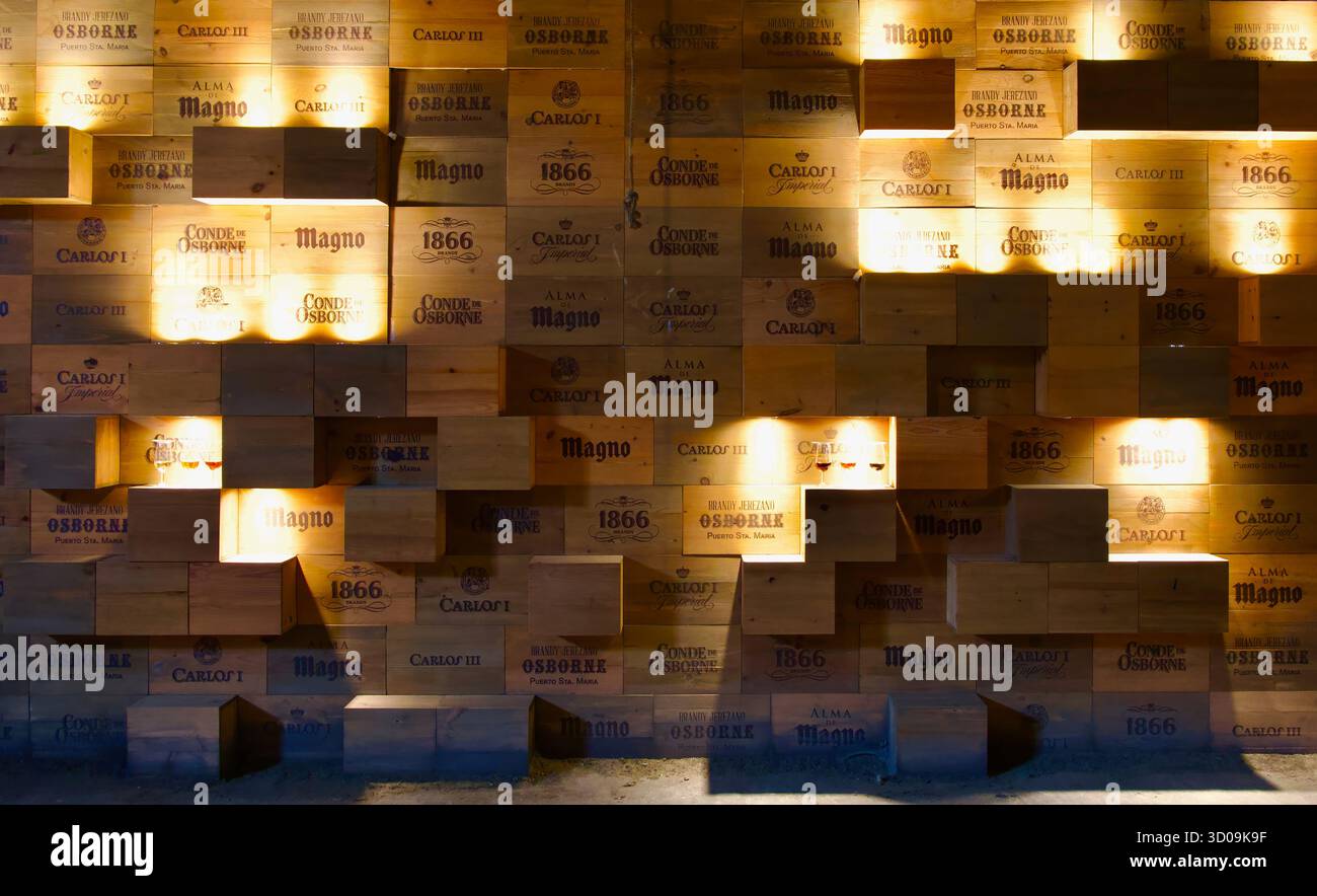Boîtes en bois contre un mur illuminé comme une exposition avec les marques de boissons Bodegas Osborne El Puerto de Santa María Cadix Andalousie Espagne Europe Banque D'Images