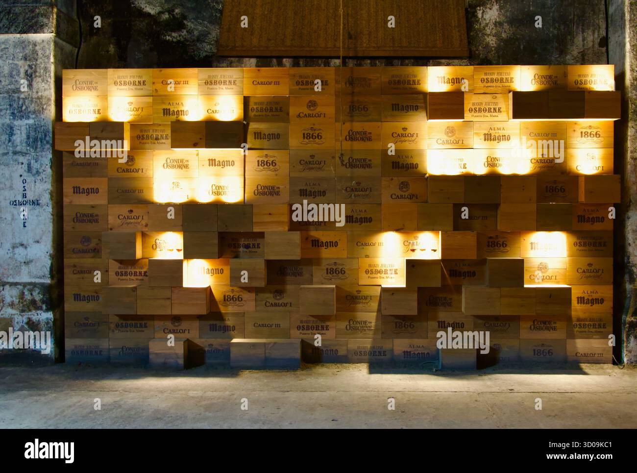 Boîtes en bois contre un mur illuminé comme une exposition avec les marques de boissons Bodegas Osborne El Puerto de Santa María Cadix Andalousie Espagne Europe Banque D'Images