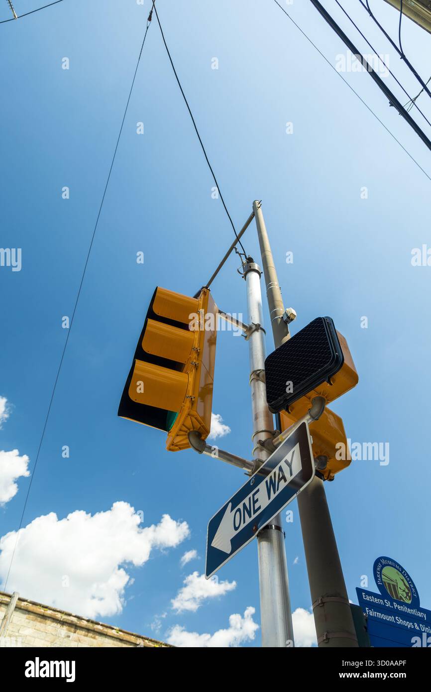 Un panneau de rue avec une flèche bleue pointant vers la droite. Le panneau de rue est sur un poteau à côté d'un feu de circulation Banque D'Images Un panneau de rue avec une flèche bleue pointant vers la droite. Le panneau de rue est sur un poteau à côté d'un feu de circulation Banque D'Images