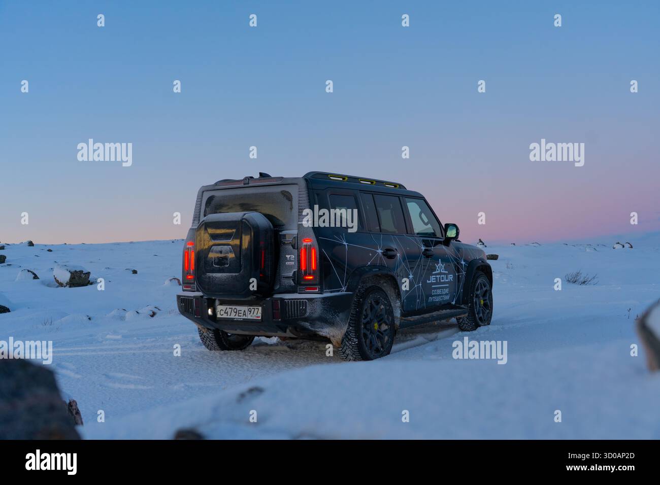 Mourmansk, Russie - 13 décembre 2024 : vue de trois quarts arrière du SUV Jetour T2 sur le vaste terrain enneigé. Vue de trois quarts arrière d'un Jetou noir Banque D'Images