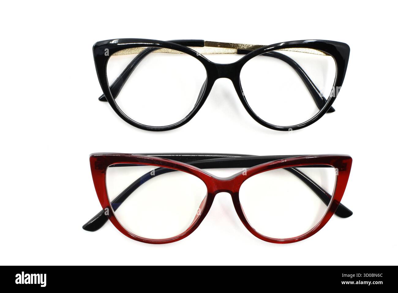 Deux paires de lunettes pour femmes avec des cadres en forme de cate Yee rouge et noir isolés sur un fond blanc Uni. Concept de vision et de vision. Banque D'Images