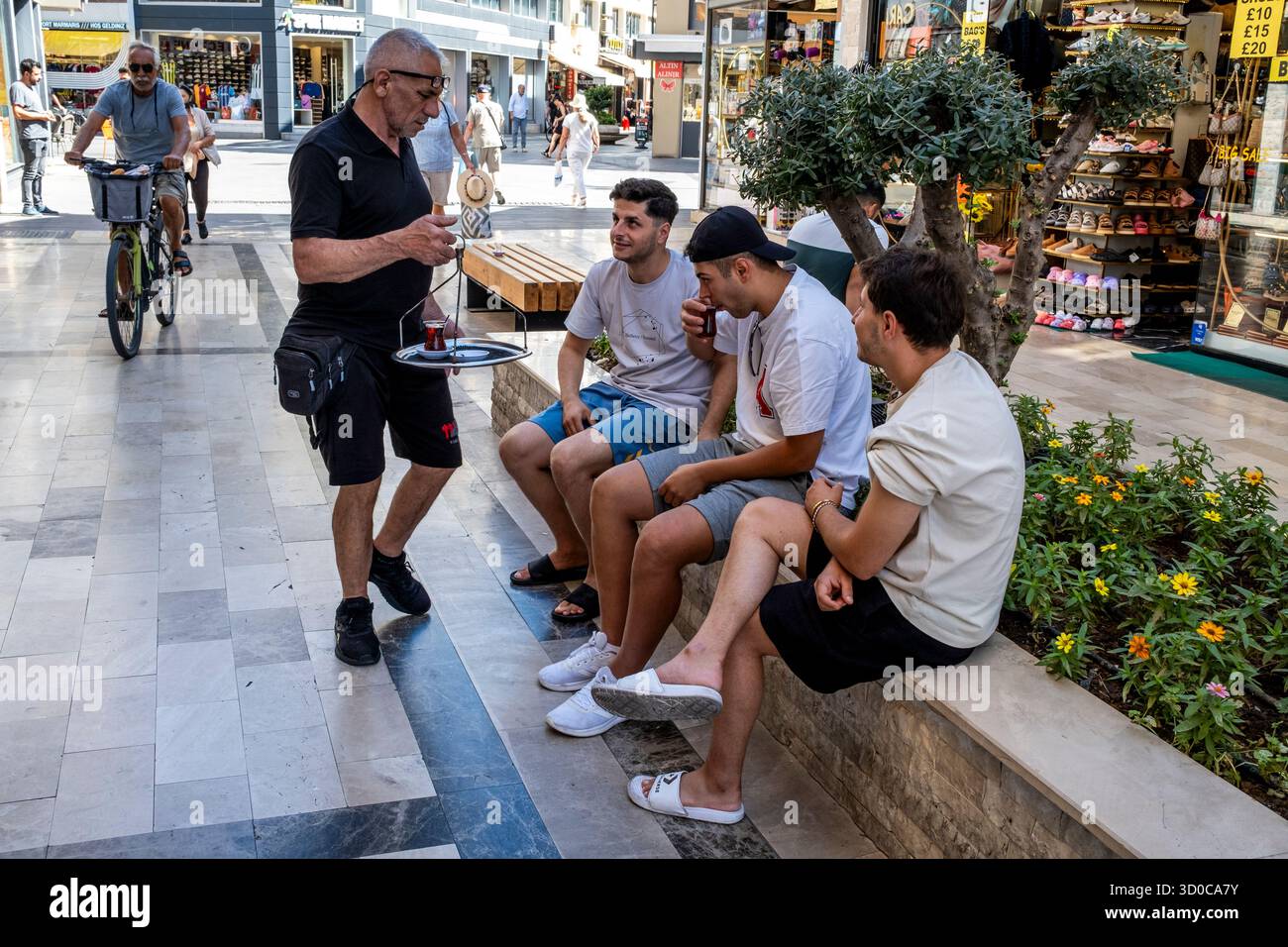 Un homme servant du thé turc à des gens dans la rue, Marmaris, province de Mugla, Turquie. Banque D'Images