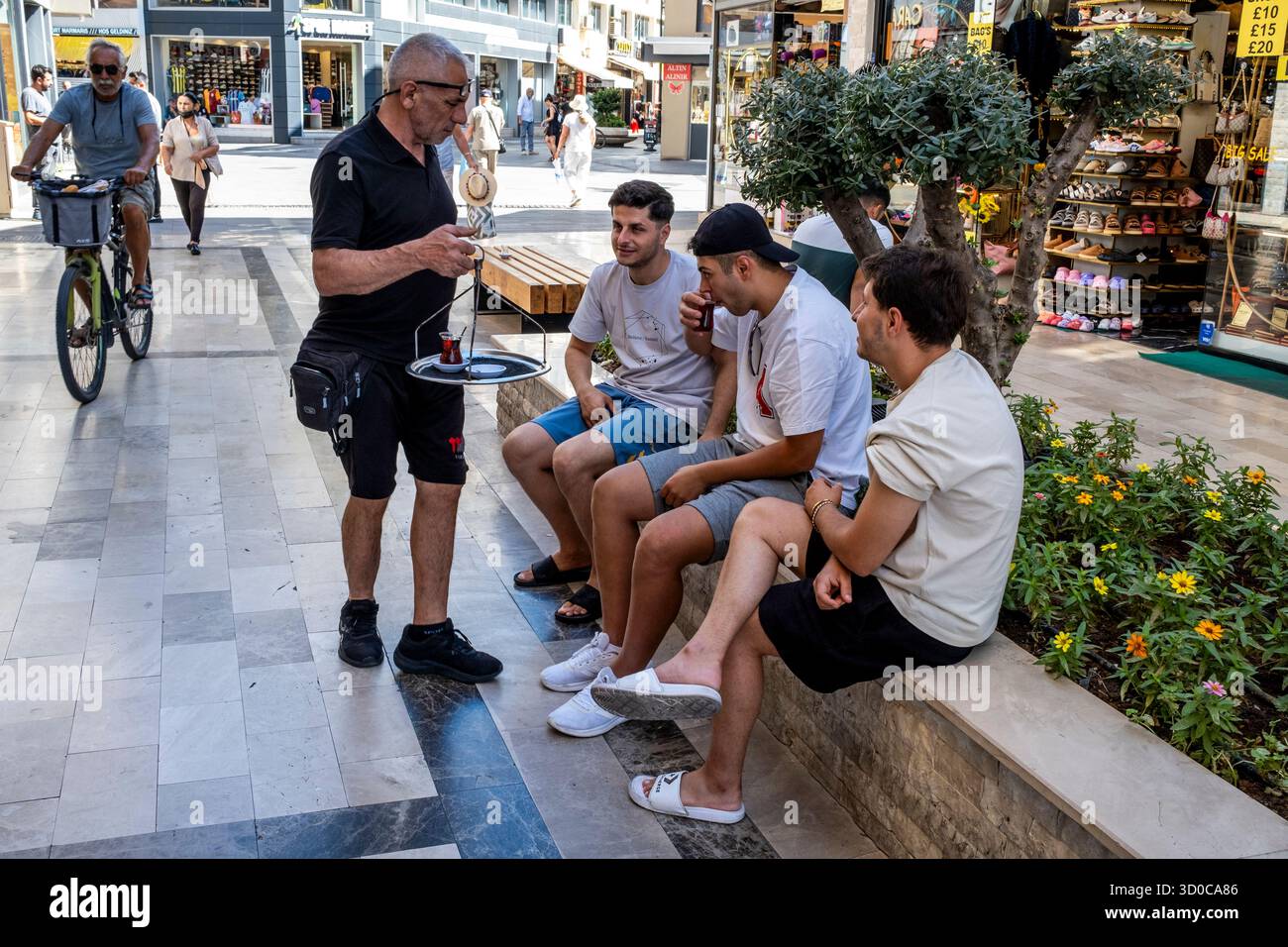 Un homme servant du thé turc à des gens dans la rue, Marmaris, province de Mugla, Turquie. Banque D'Images
