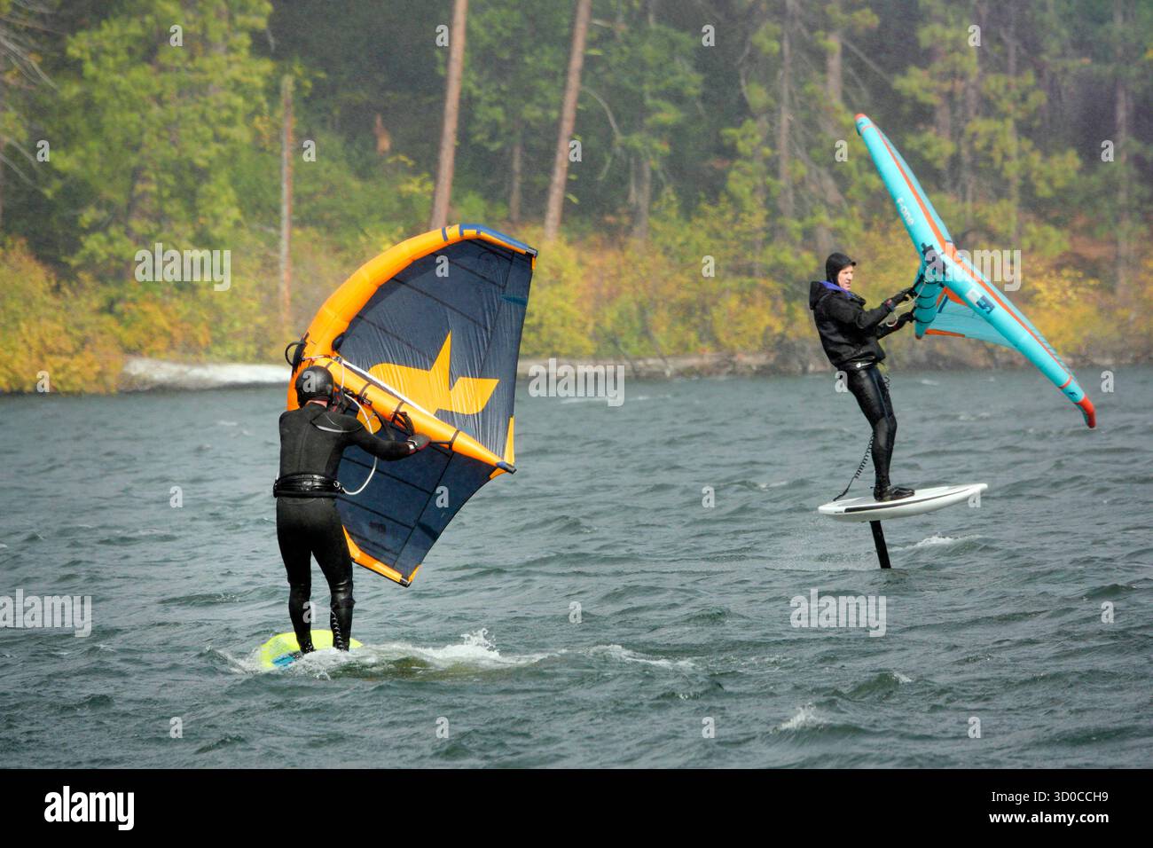 Voilage (également connu sous le nom de Wing Surf ou Winging) avec un vent fort soufflant sur le lac Suttle dans les montagnes Cascade du centre de l'Oregon en octobre. Banque D'Images