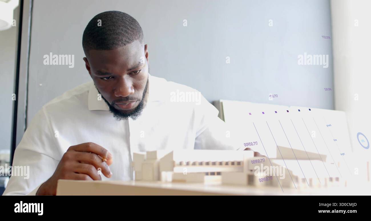 Examinant architecte portant une chemise blanche étudiant modèle réduit dans le bureau, avec crayon et tableau graphique Banque D'Images