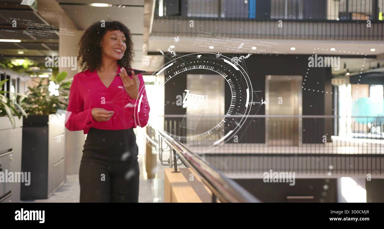 Femme marchante faisant des gestes, présentant sur le balcon de l'atrium du bureau avec des plantes, des graphiques HUD, un espace de copie Banque D'Images