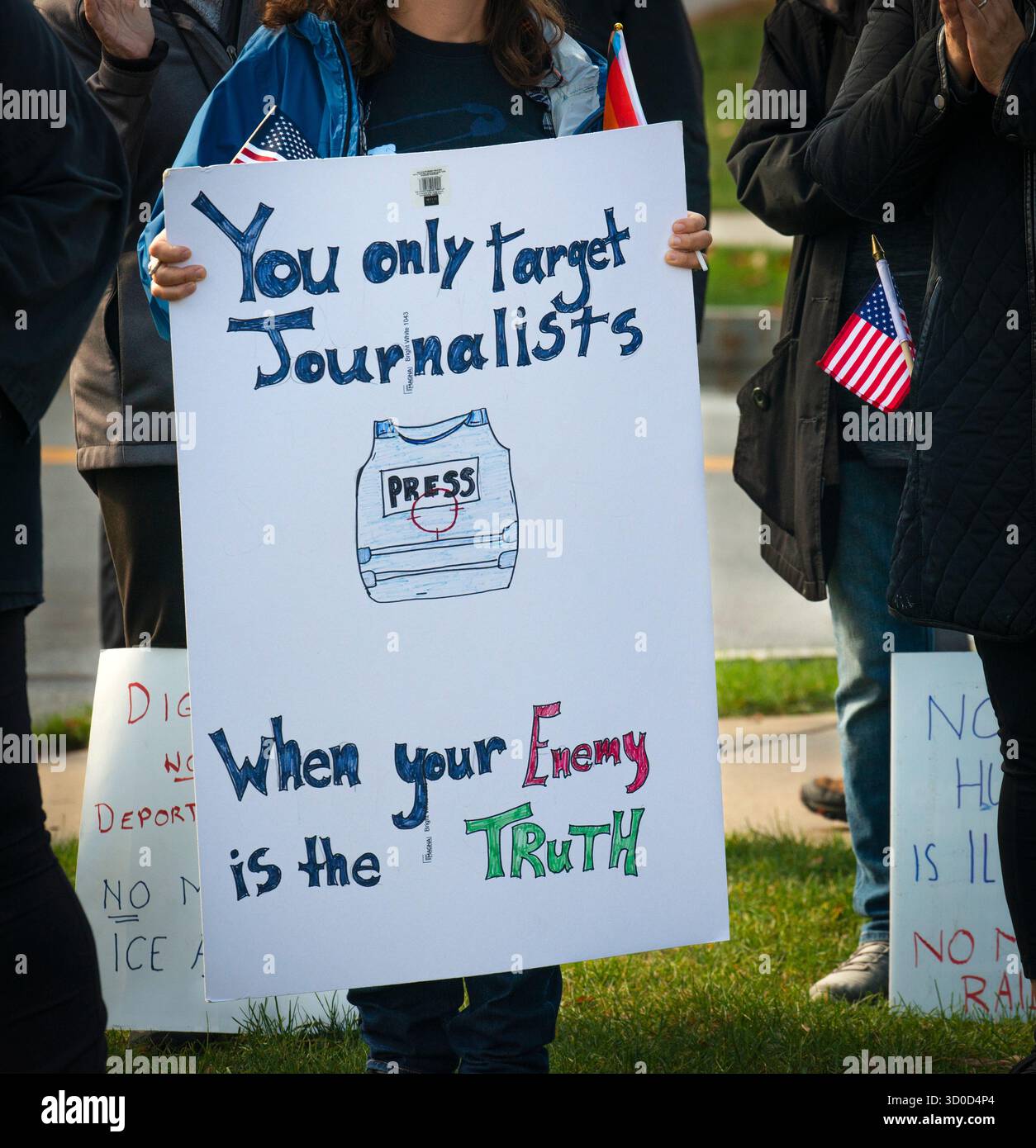 Burlington, Massachusetts, États-Unis. 22 octobre 2025. Une manifestante tient une pancarte faite maison soutenant la presse, les médias et le journalisme lors de la 27e manifestation hebdomadaire anti-ICE « portant témoin » devant le bureau de terrain de l'Immigration and Customs Enforcement (ICE) de la Nouvelle-Angleterre, à 26 km au nord-ouest de Boston, ma. Les organisateurs ont estimé que la manifestation hebdomadaire à midi de cette semaine a atteint plus de 600 personnes. Crédit : Chuck Nacke / Alamy Live News Banque D'Images
