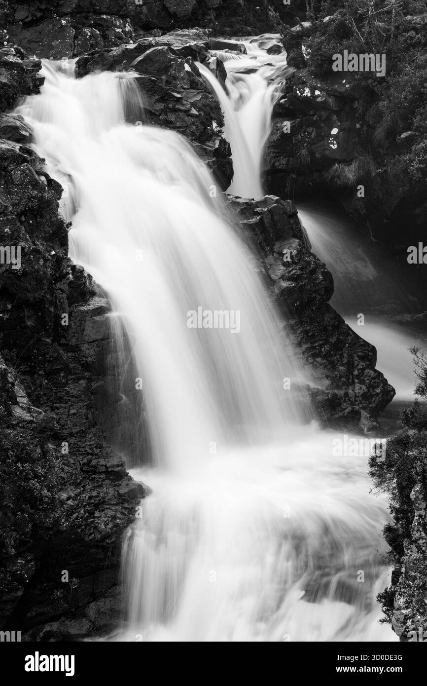 Vue en noir et blanc sur les chutes de Glenbrittle qui descendent en cascade sur les rochers accidentés de l'île de Skye Banque D'Images