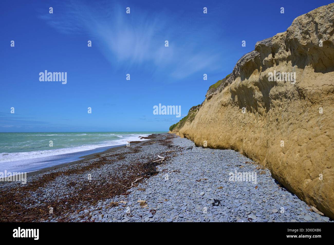 Falaise avec plage de galets et ciel bleu par une journée ensoleillée, phare de Tuhawaiki point ou phare de Jack's point, Scarborough, Timaru, Île du Sud, Nouvelle-Zélande Banque D'Images
