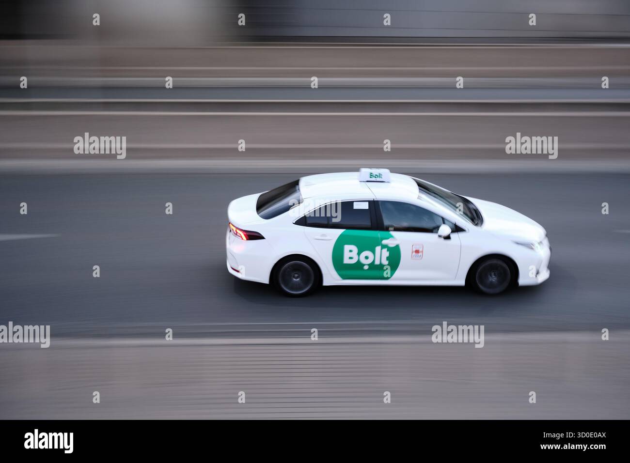 Lodz, Pologne - 17 septembre 2025 : voiture de taxi Bolt conduisant dans la rue de la ville dans le flou de mouvement. Banque D'Images