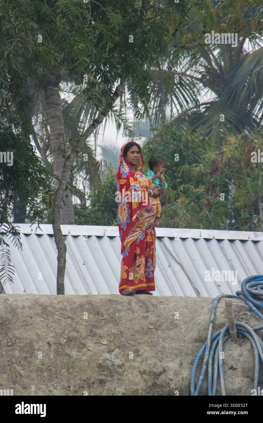 SUNDARBANS, BENGALE OCCIDENTAL, INDE - 16 FÉVRIER 2024 femmes sur la rive du delta du Gange, Brahmapoutre et Meghna Banque D'Images