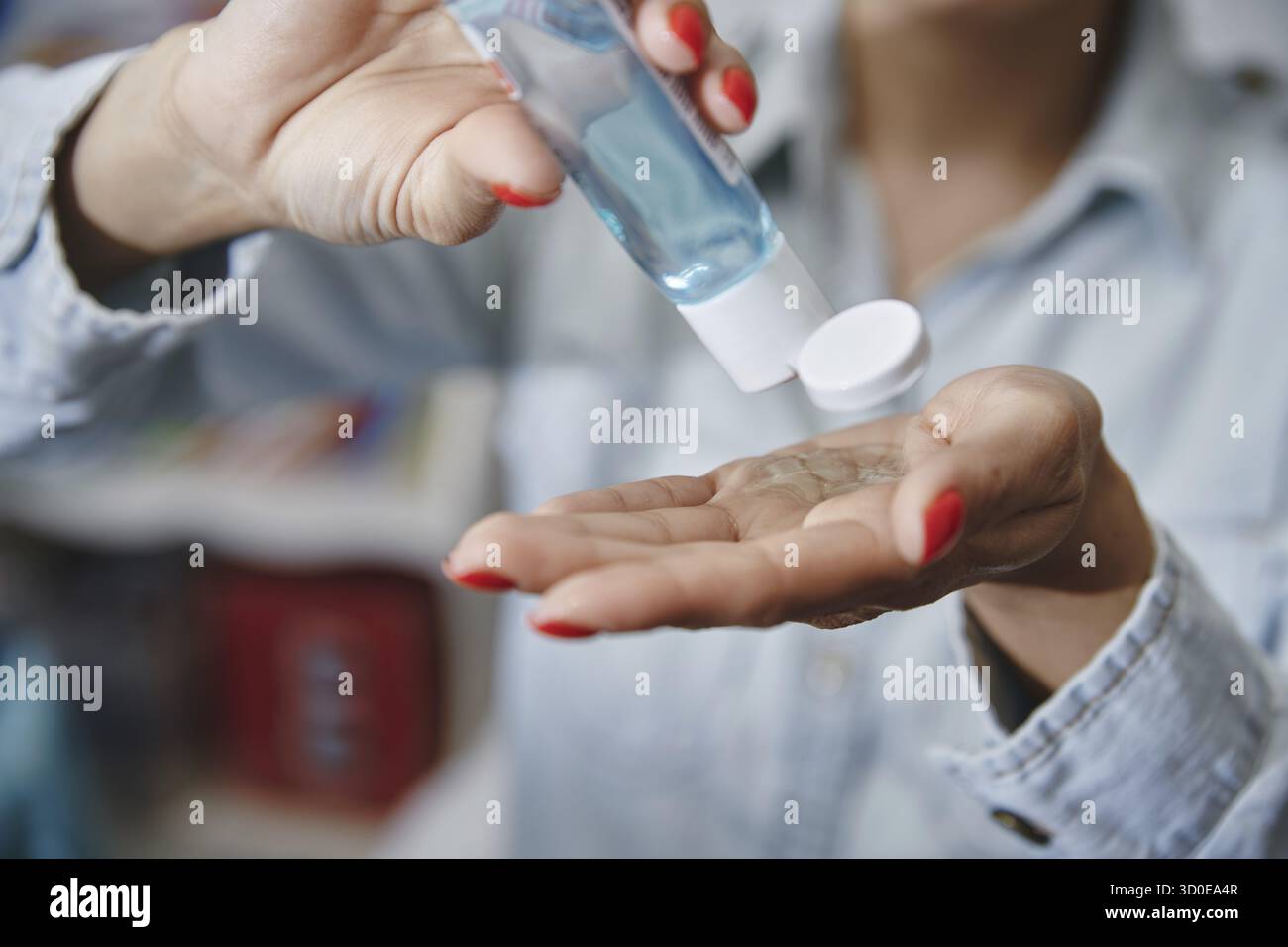Femme utilisant une lotion hydratante pour la désinfection Banque D'Images