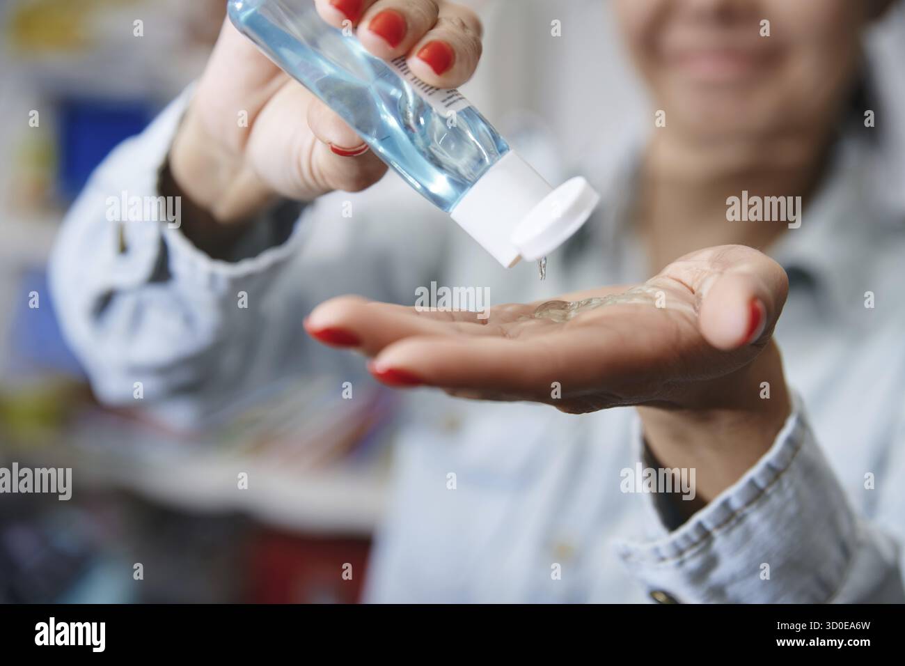 Femme utilisant une lotion hydratante pour la désinfection Banque D'Images
