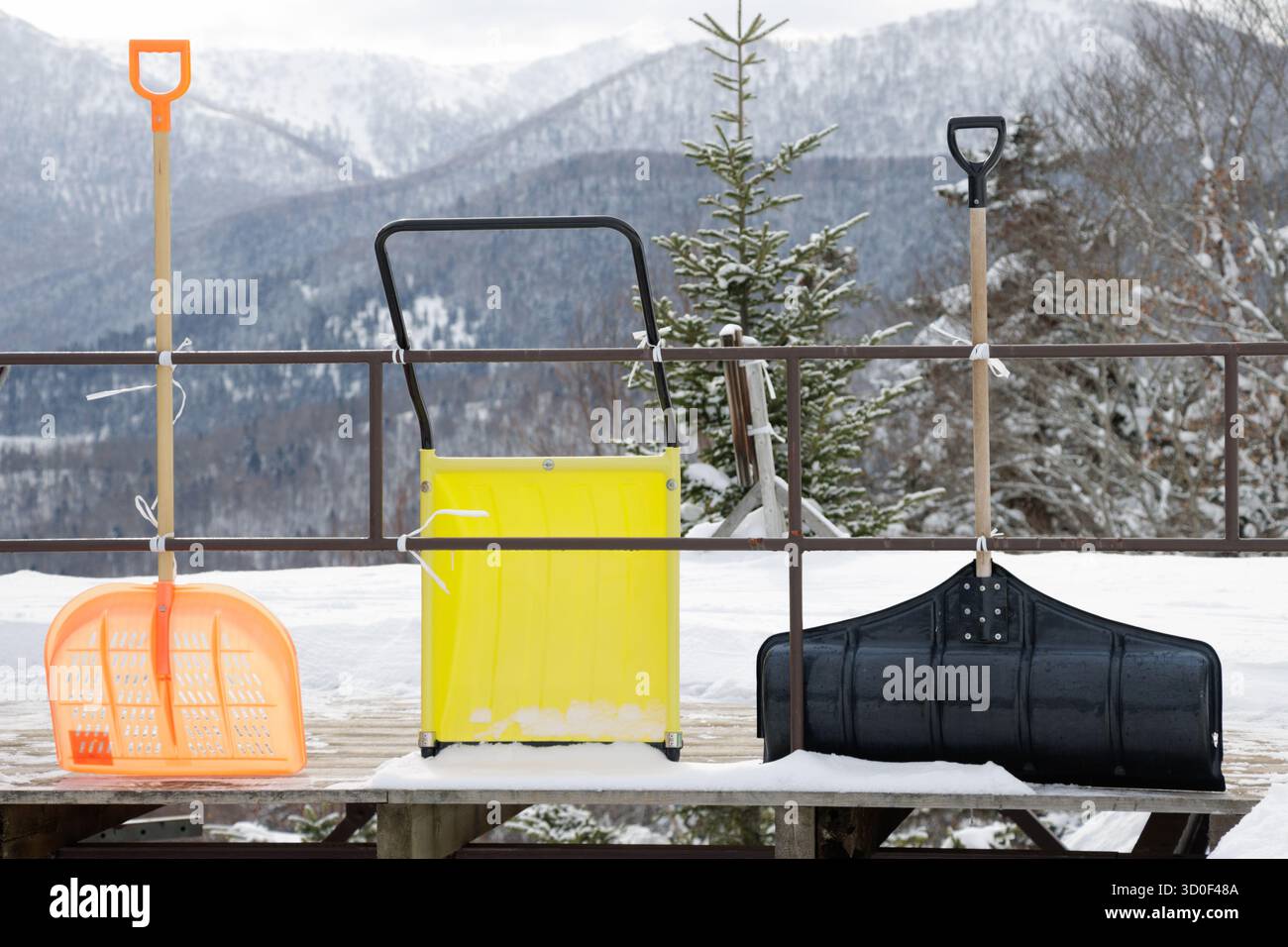 Pelles à neige orange, jaune et noire dans le paysage hivernal Banque D'Images