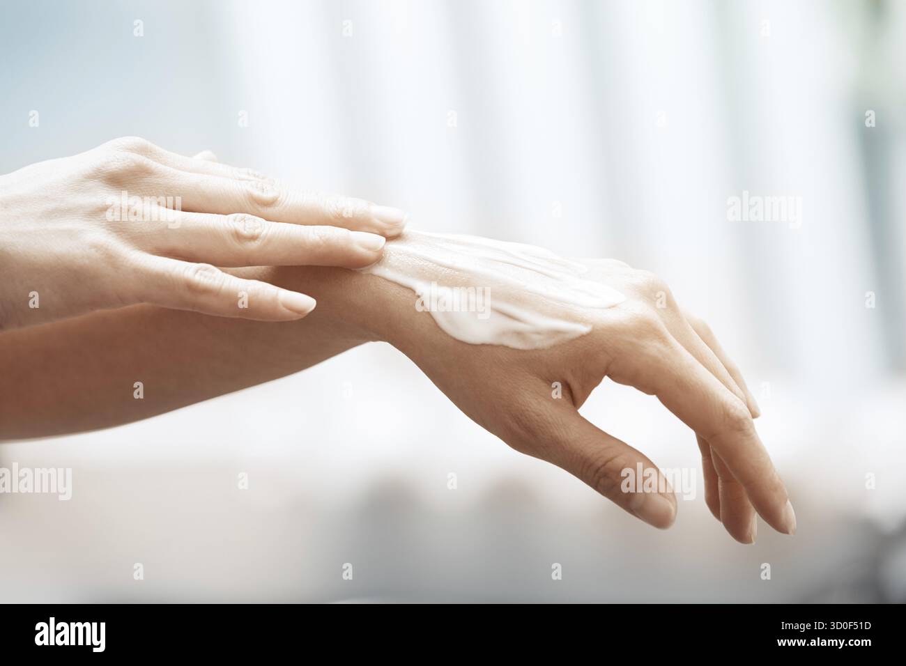 L'application de crème hydratante femme sur les mains Banque D'Images