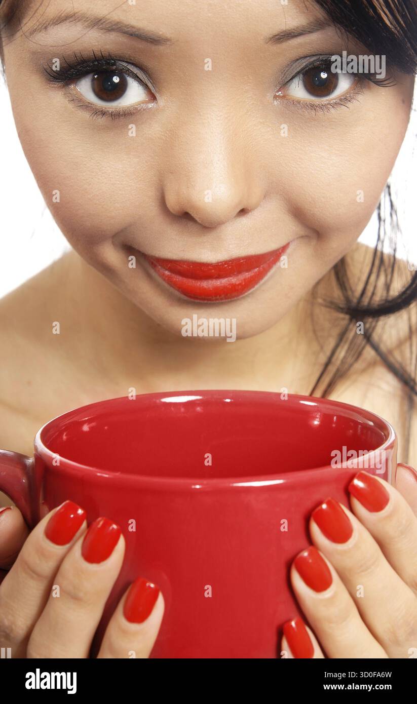 Smiling model holding red cup avec verre ou manger Banque D'Images