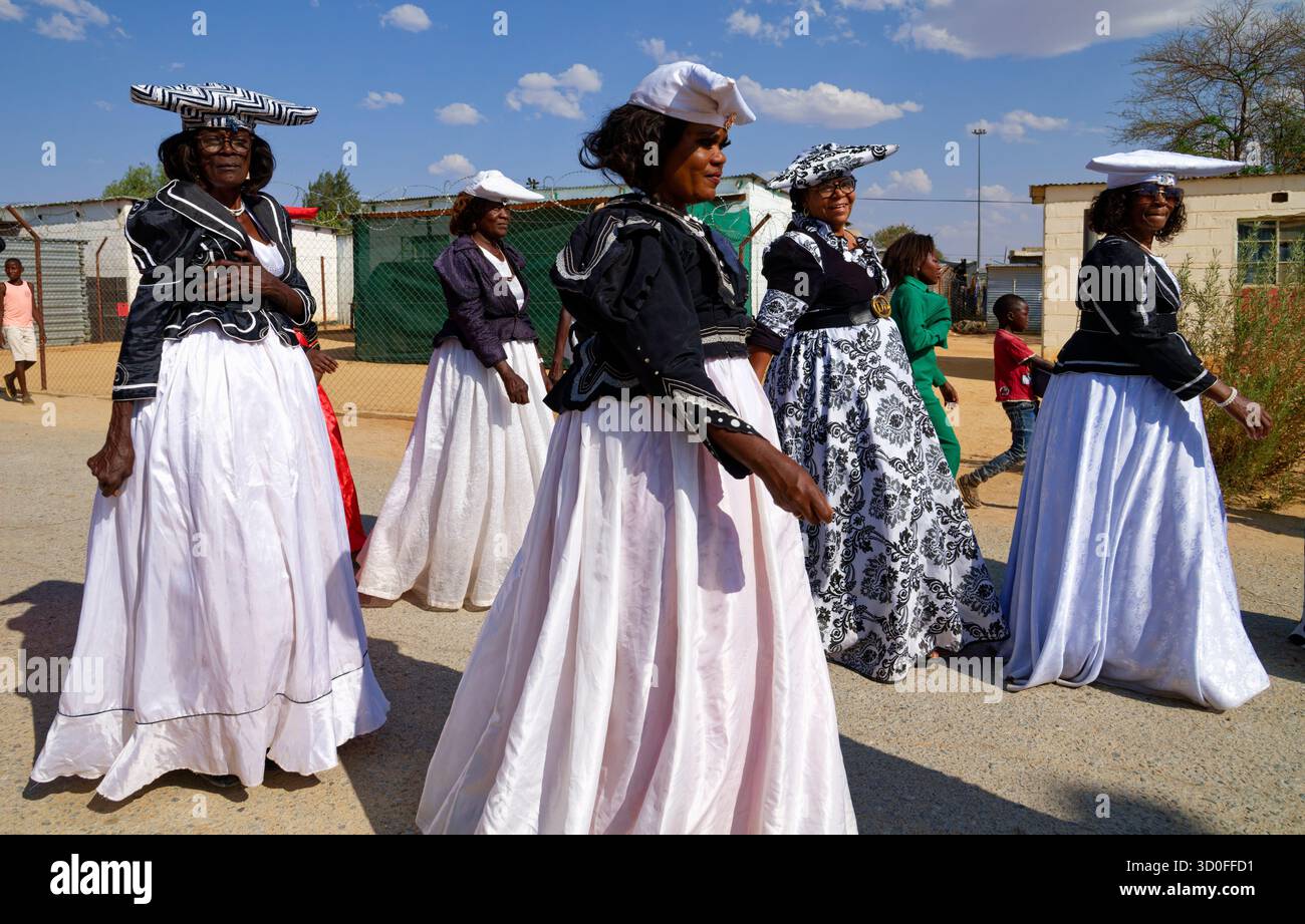 Omaruru : Herero Day à la Maison Royale de Zeraeua (drapeau blanc), défilé de femmes Herero en tenue traditionnelle dans le district d'Ozondje (quartier noir), Namibie Banque D'Images
