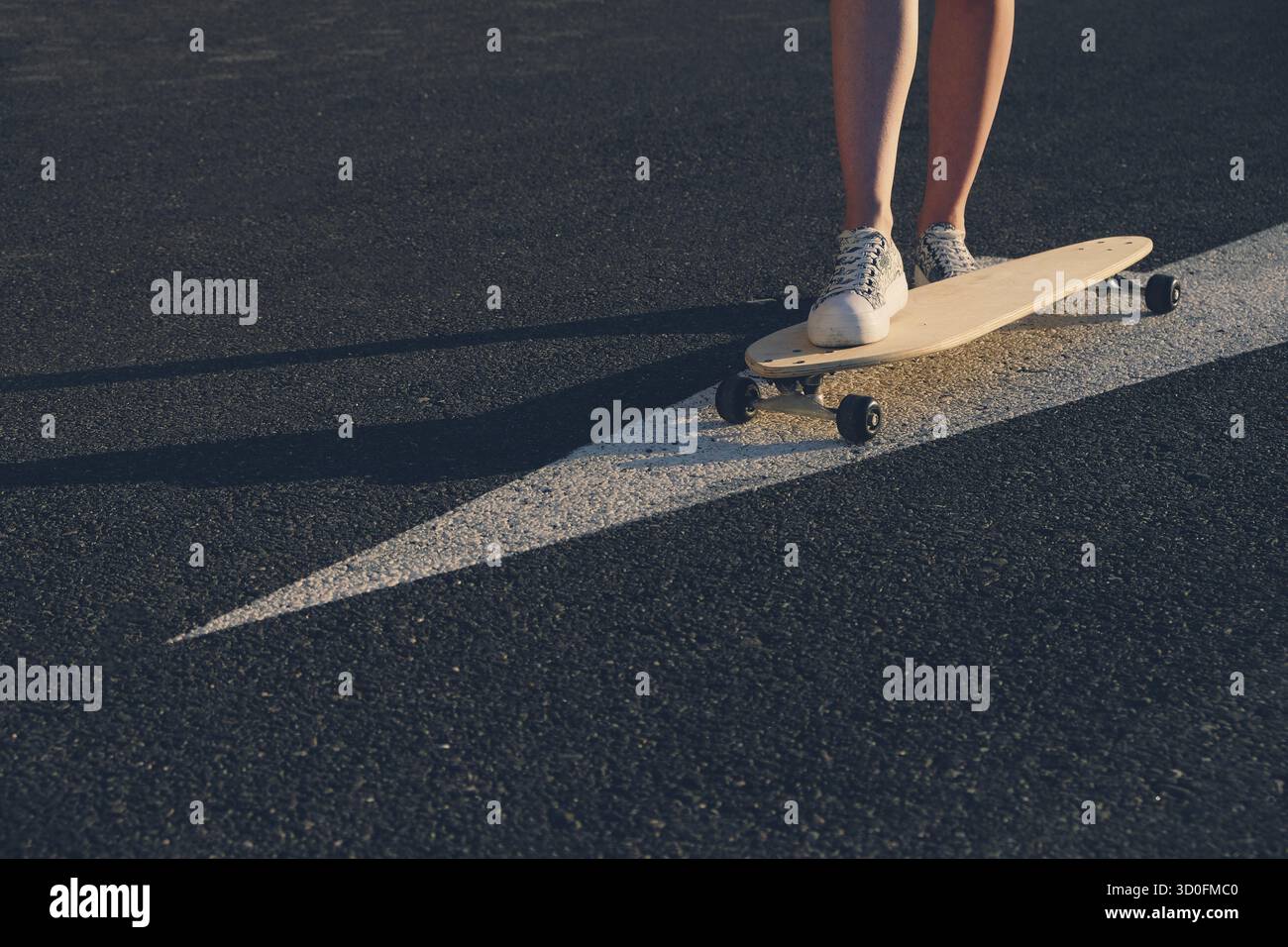 Roulettes sur painyed sur flèche d'asphalte, les jambes sur la carte Banque D'Images