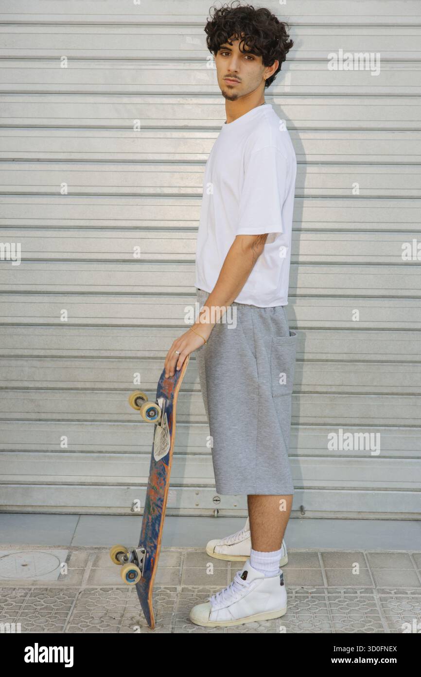 Skateur urbain en vêtements athlétiques regardant la caméra Banque D'Images