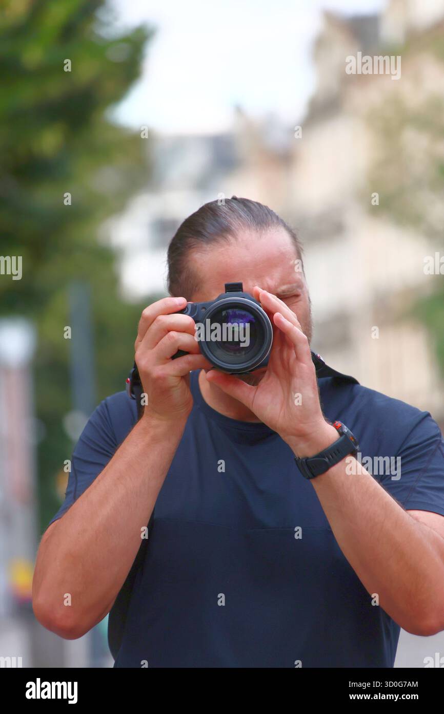 Photographe se concentrant sur son objectif en extérieur Banque D'Images