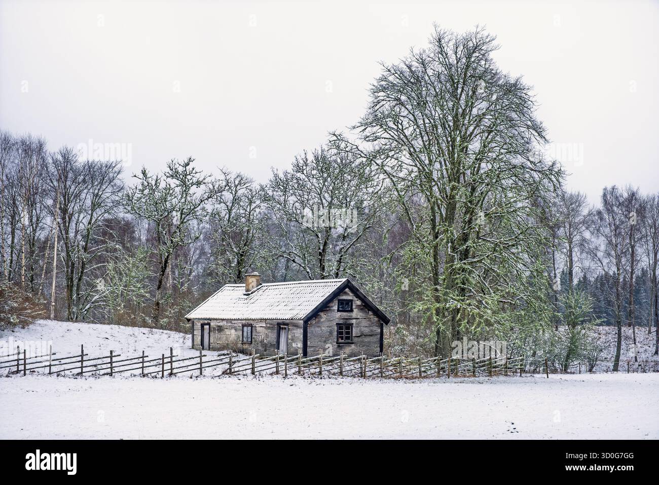 Ancien chalet en bois dans une campagne enneigée Banque D'Images