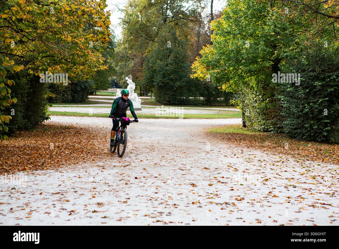 Promenades cyclistes le long du sentier couvert de feuilles du parc pendant la saison d'automne en profitant de l'exercice en plein air et de l'environnement naturel autour. Banque D'Images