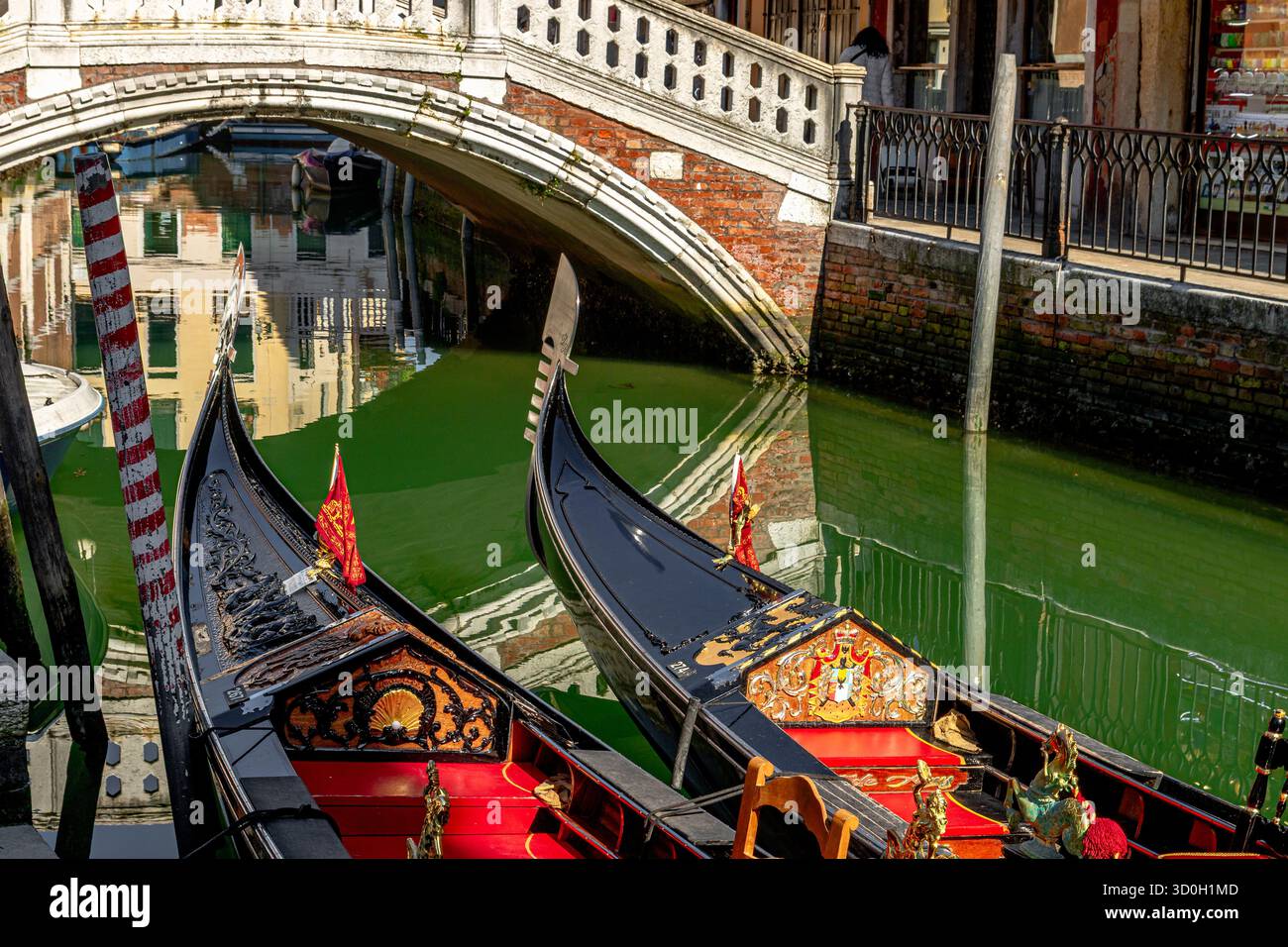 La proue de fer ou les lames avant de deux gondoles amarrées côte à côte près de Ponte Frari sur le canal Rio dei Frari à San Polo, Venise, Italie Banque D'Images