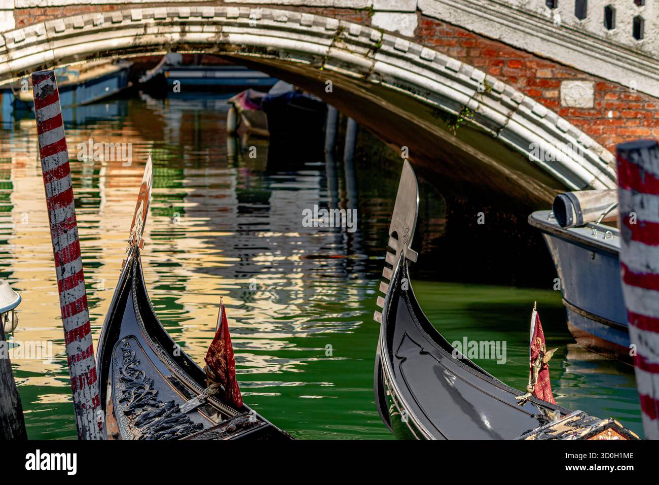 La proue de fer ou les lames avant de deux gondoles amarrées côte à côte près de Ponte Frari sur le canal Rio dei Frari à San Polo, Venise, Italie Banque D'Images