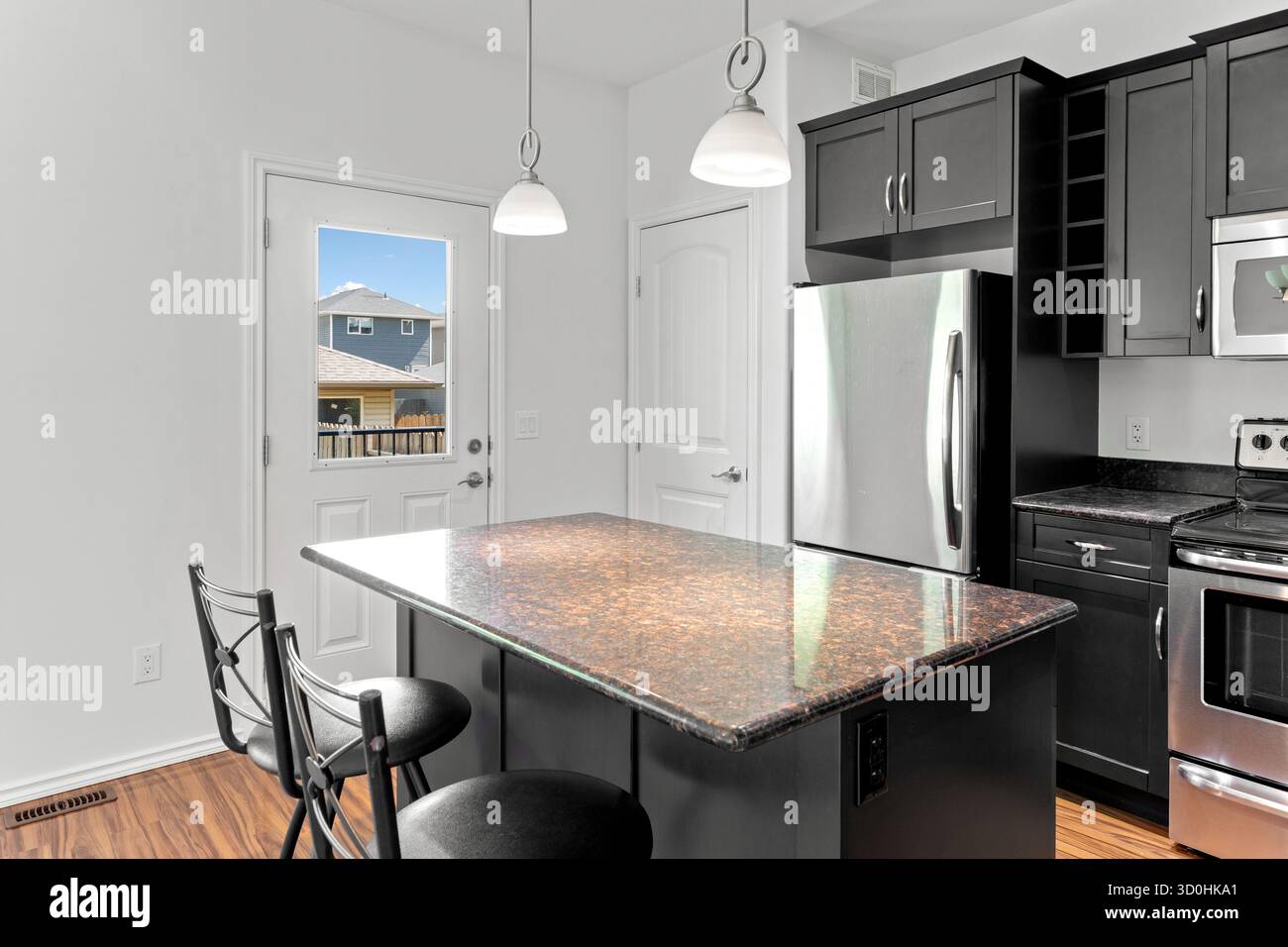 Cuisine avec comptoir en granit noir et appareils électroménagers en acier inoxydable. La cuisine a un design moderne et élégant Banque D'Images