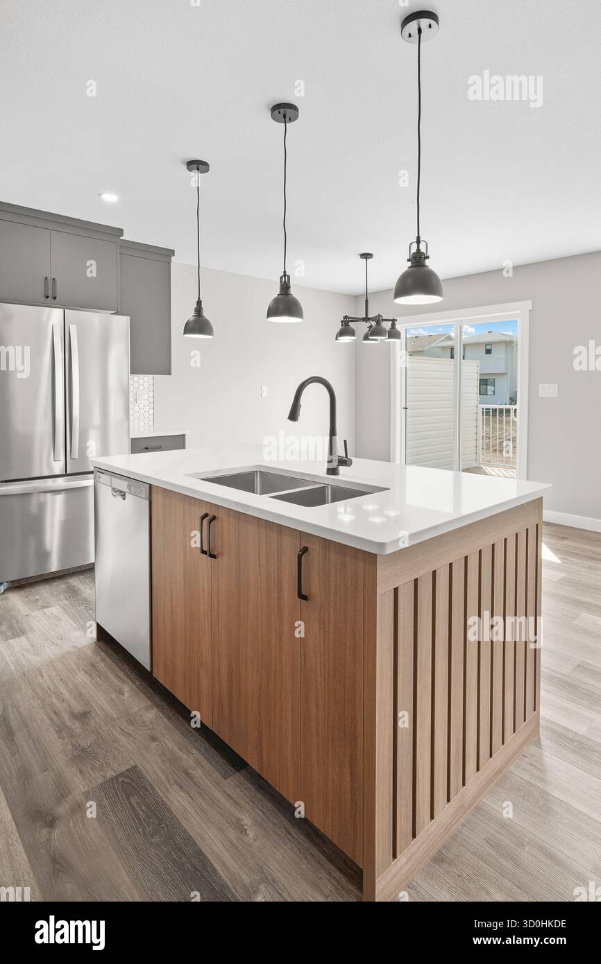 Cuisine avec îlot en bois et appareils électroménagers en acier inoxydable. La cuisine a un look moderne et propre Banque D'Images