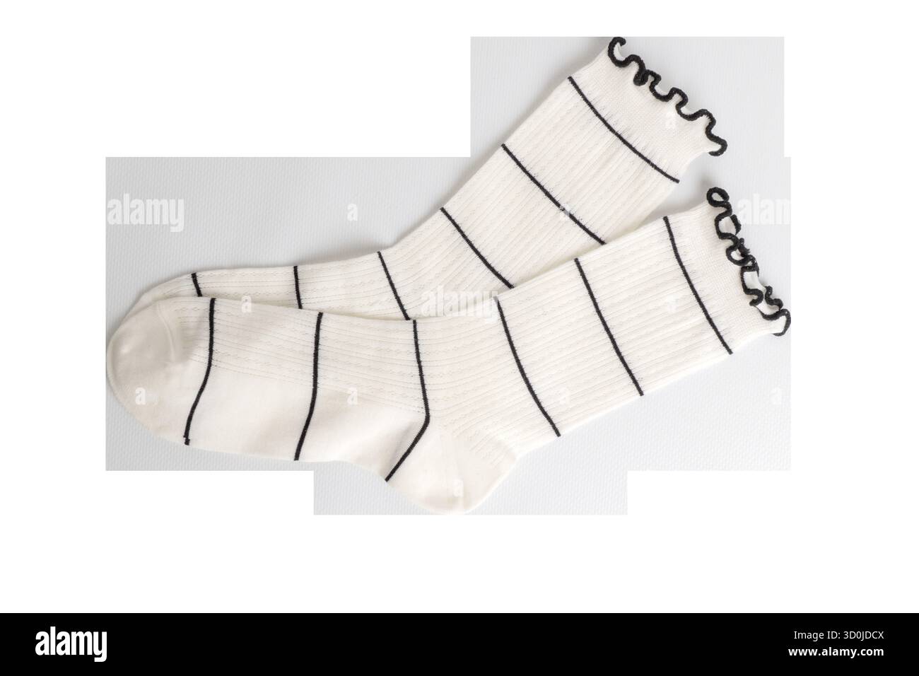 Chaussettes blanches confortables avec des rayures noires et des bords volants sur fond noir Banque D'Images