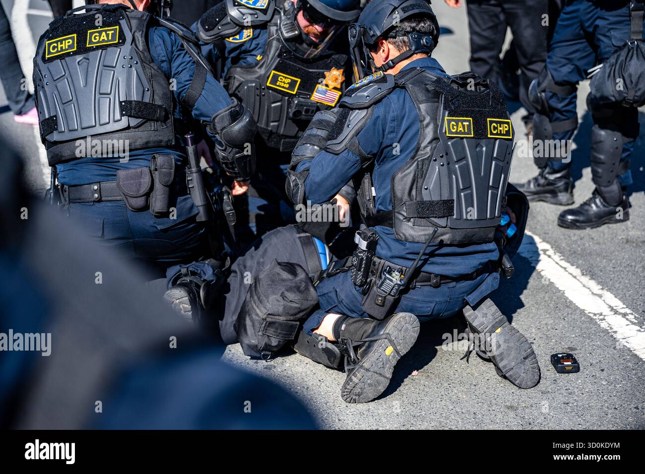 Oakland, Californie, États-Unis. 23 octobre 2025. 23 octobre 2025 : des officiers du CHP en tenue anti-émeute arrêtent un manifestant lors d'une manifestation contre la glace au pont de l'île des gardes-côtes à Oakland VERS LE 23 octobre 2025 (image crédit : © Trinity Machan/ZUMA Press Wire) USAGE ÉDITORIAL SEULEMENT ! Non destiné à UN USAGE commercial ! Banque D'Images Oakland, Californie, États-Unis. 23 octobre 2025. 23 octobre 2025 : des officiers du CHP en tenue anti-émeute arrêtent un manifestant lors d'une manifestation contre la glace au pont de l'île des gardes-côtes à Oakland VERS LE 23 octobre 2025 (image crédit : © Trinity Machan/ZUMA Press Wire) USAGE ÉDITORIAL SEULEMENT ! Non destiné à UN USAGE commercial ! Banque D'Images