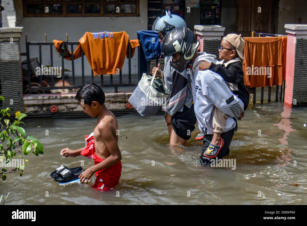 Bandung Regency, Java occidental, Indonésie. 24 octobre 2025. Un résident porte un enfant pendant les inondations dans le village de Bojongasih, Dayeuhkolot, Bandung Regency, Java occidental. Les fortes pluies qui ont frappé Bandung à partir du jeudi 23 octobre, de l’après-midi au soir, ont laissé des centaines de maisons et de routes dans la Régence de Bandung submergées par des eaux de crue jusqu’à 40 centimètres de profondeur. (Crédit image : © Dimas Rachmatsyah/ZUMA Press Wire) USAGE ÉDITORIAL SEULEMENT ! Non destiné à UN USAGE commercial ! Banque D'Images Bandung Regency, Java occidental, Indonésie. 24 octobre 2025. Un résident porte un enfant pendant les inondations dans le village de Bojongasih, Dayeuhkolot, Bandung Regency, Java occidental. Les fortes pluies qui ont frappé Bandung à partir du jeudi 23 octobre, de l’après-midi au soir, ont laissé des centaines de maisons et de routes dans la Régence de Bandung submergées par des eaux de crue jusqu’à 40 centimètres de profondeur. (Crédit image : © Dimas Rachmatsyah/ZUMA Press Wire) USAGE ÉDITORIAL SEULEMENT ! Non destiné à UN USAGE commercial ! Banque D'Images