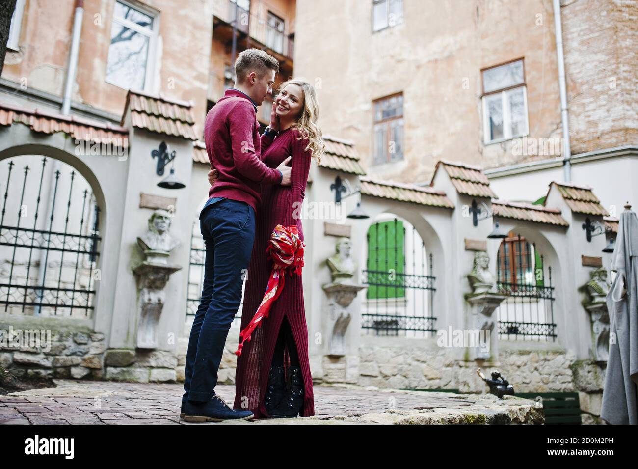 Beau jeune couple mode dans une robe rouge à l'histoire d'amour à la vieille ville Banque D'Images