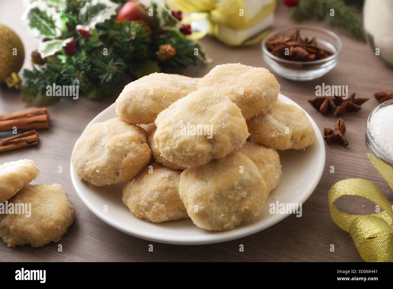 Pile de biscuits à l'anis sur plaque blanche avec cannelle et sucre sur une table en bois décorée de motifs festifs. Vue surélevée. Banque D'Images