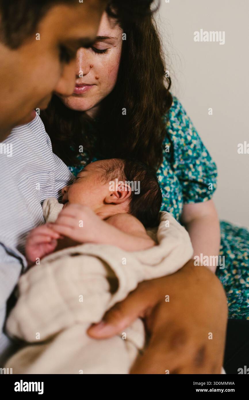 Mère et père tenant le bébé nouveau-né latino ensemble dans l'amour Banque D'Images