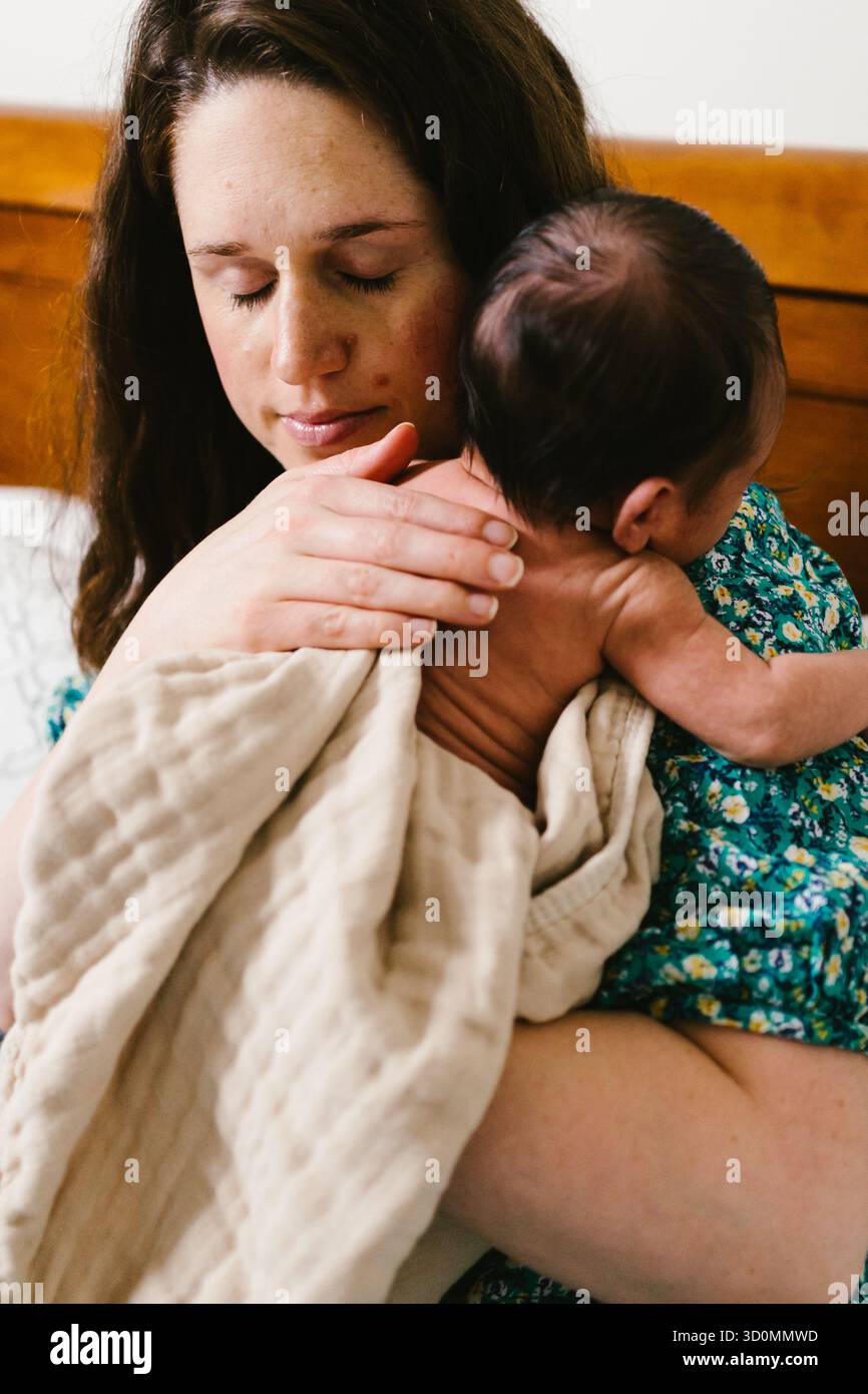 Mère tenant le bébé nouveau-né avec amour et tendresse Banque D'Images