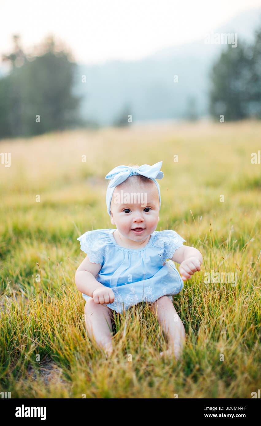 Jeune bébé assis dans l'herbe Banque D'Images