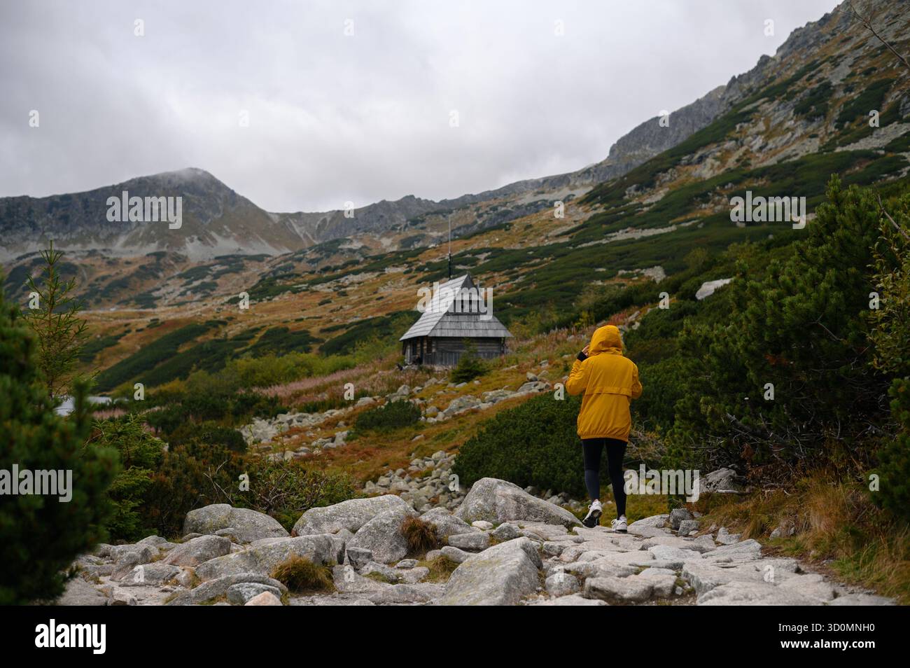 Randonneur approchant Mountain Cabin en automne Banque D'Images