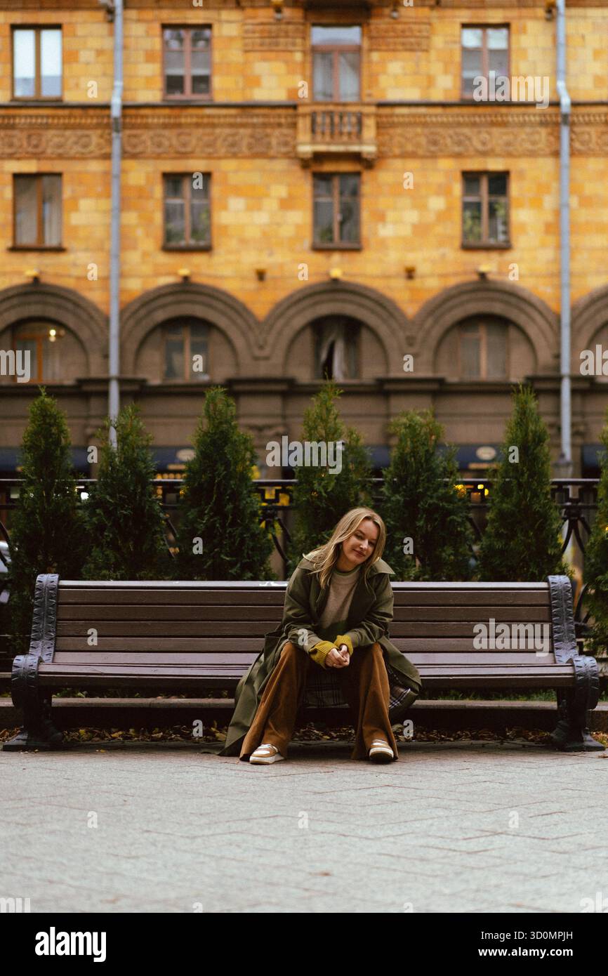 Femme assise sur un banc dans la ville Banque D'Images