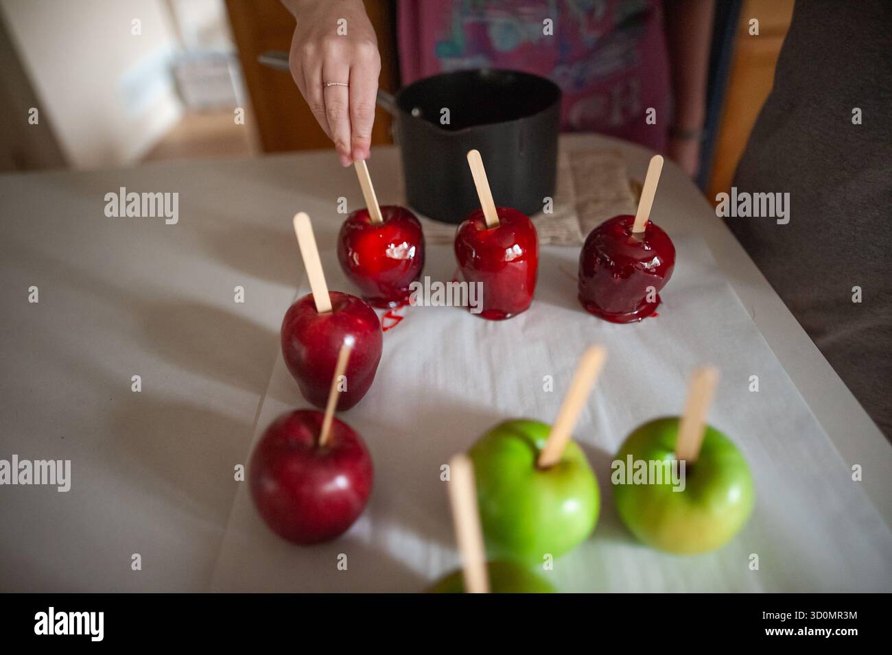 Pommes bonbons colorées placées sur du parchemin après avoir été trempées Banque D'Images