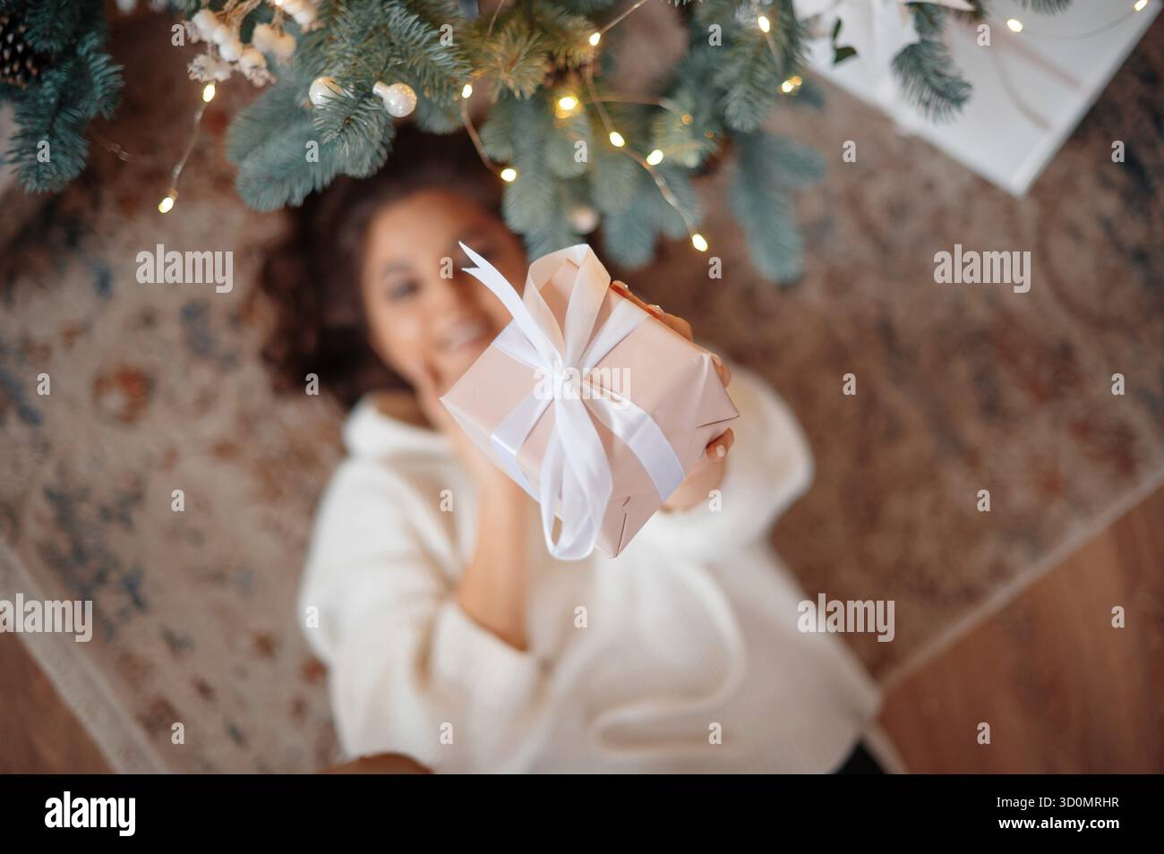 Belle jeune fille posant l'arbre de Noël dans la maison en bois d'hiver Banque D'Images