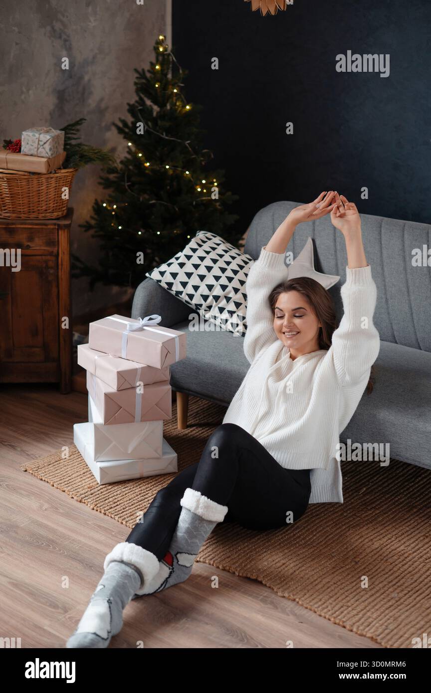 Femme positive étirant les mains le matin après Noël Banque D'Images