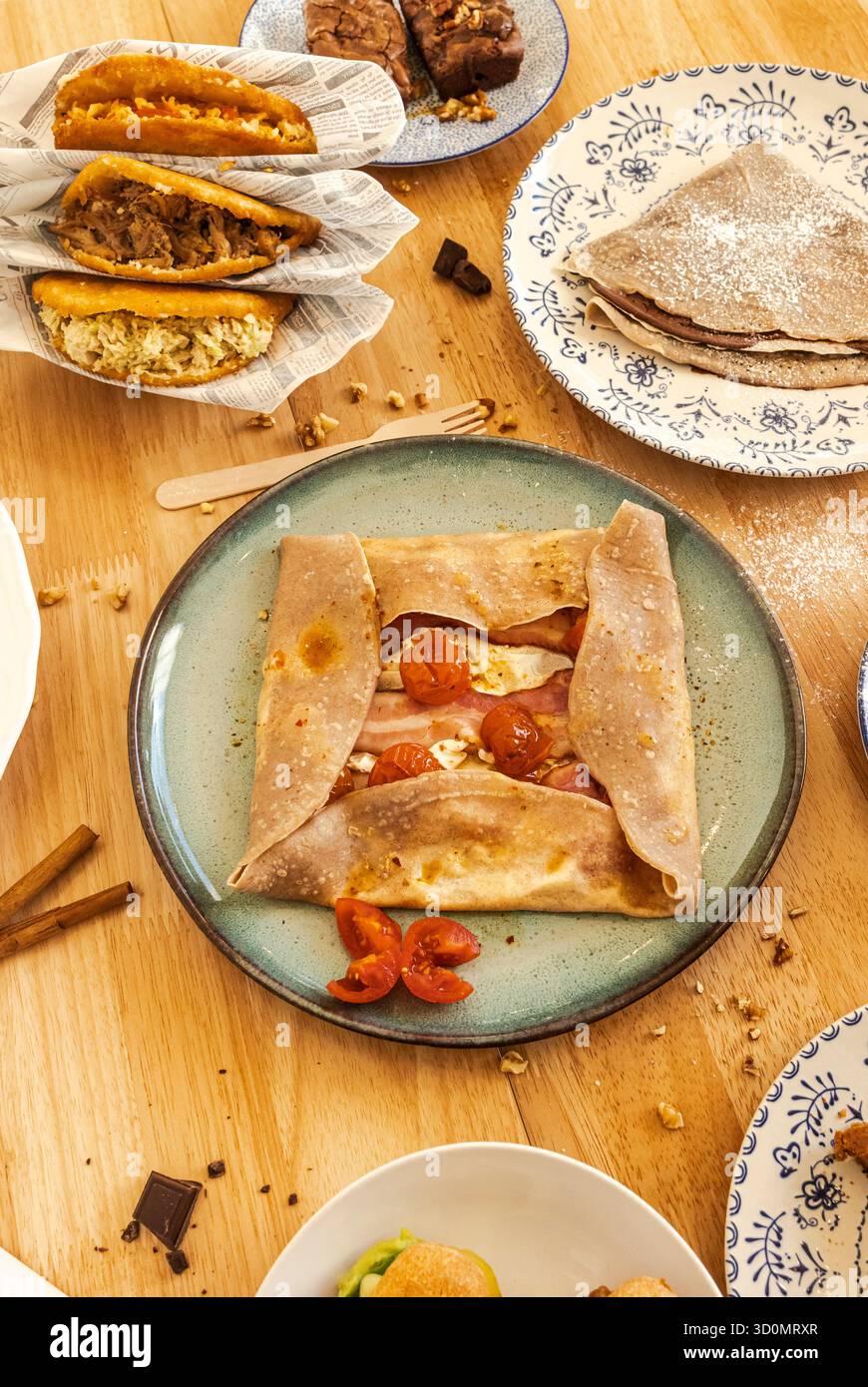 Table de brunch proposant crêpes salées, arepas et desserts sucrés Banque D'Images