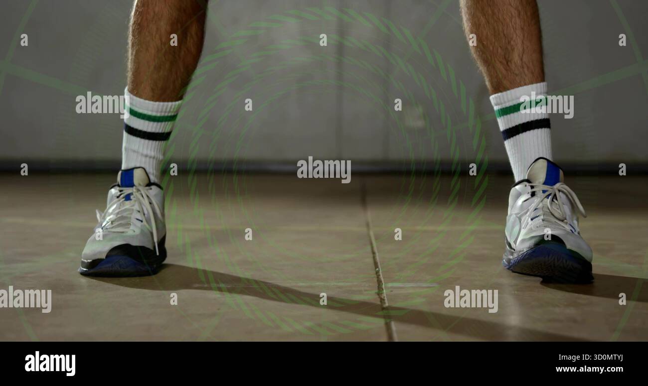 Montrant les jambes et les pieds fléchis sur le terrain de gymnastique avec des chaussures bleues blanches, des chaussettes rayées, un revêtement vert Banque D'Images