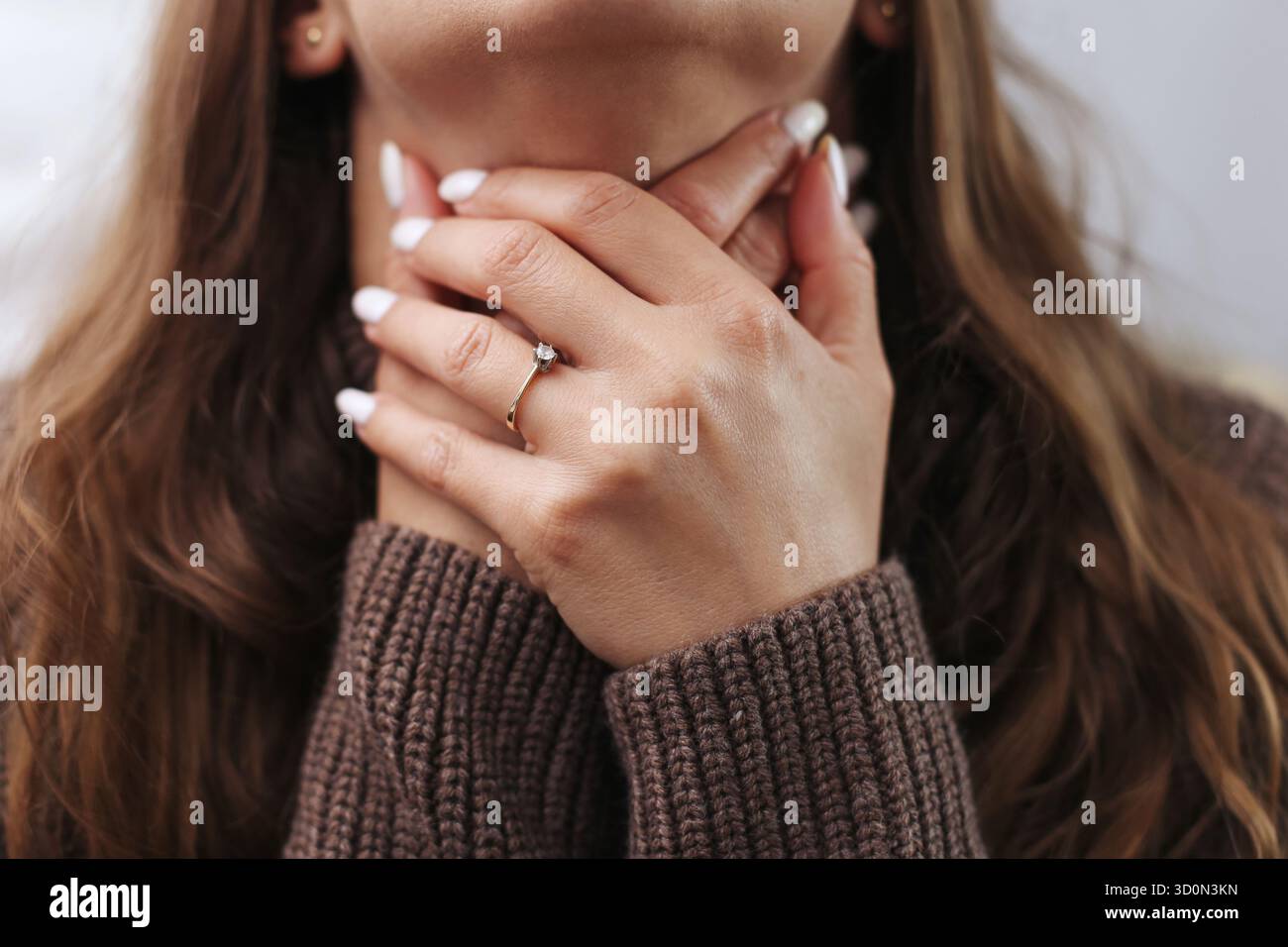 Mal de gorge gênant à la maison. Femme touchant le cou avec les mains. Concept de symptôme du rhume et de la grippe. Problème de santé et sensation de douleur. Banque D'Images