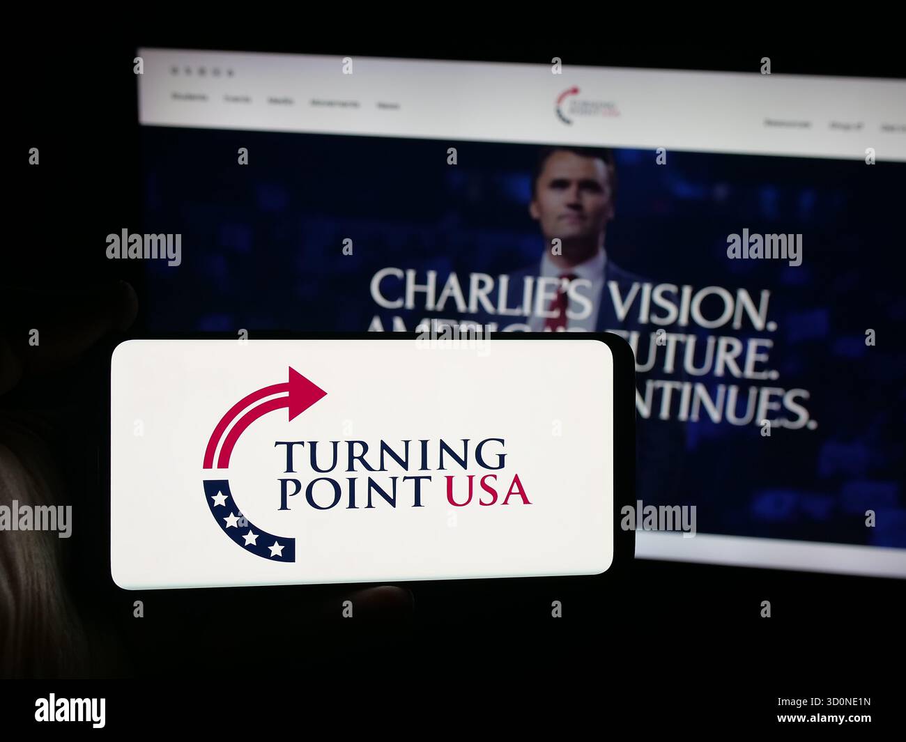 Stuttgart, Allemagne - 10-15-2025 : personne tenant un smartphone avec le logo de l'organisation américaine Turning point USA (TPUSA) sur l'écran devant le site Web. Mise au point Banque D'Images