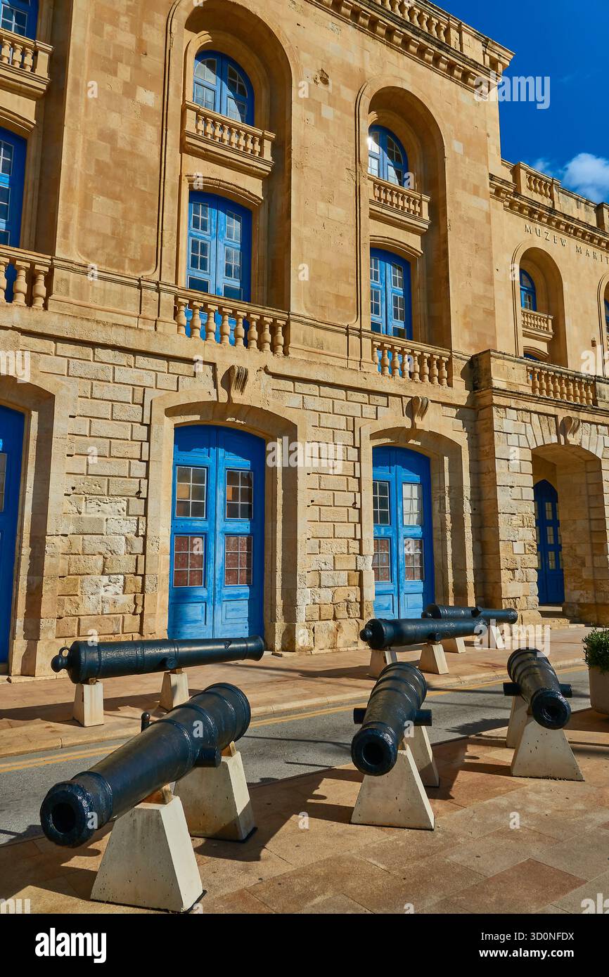 Musée maritime historique en pierre à Birgu, Malte avec portes bleues et canons exposés dans la cour Banque D'Images