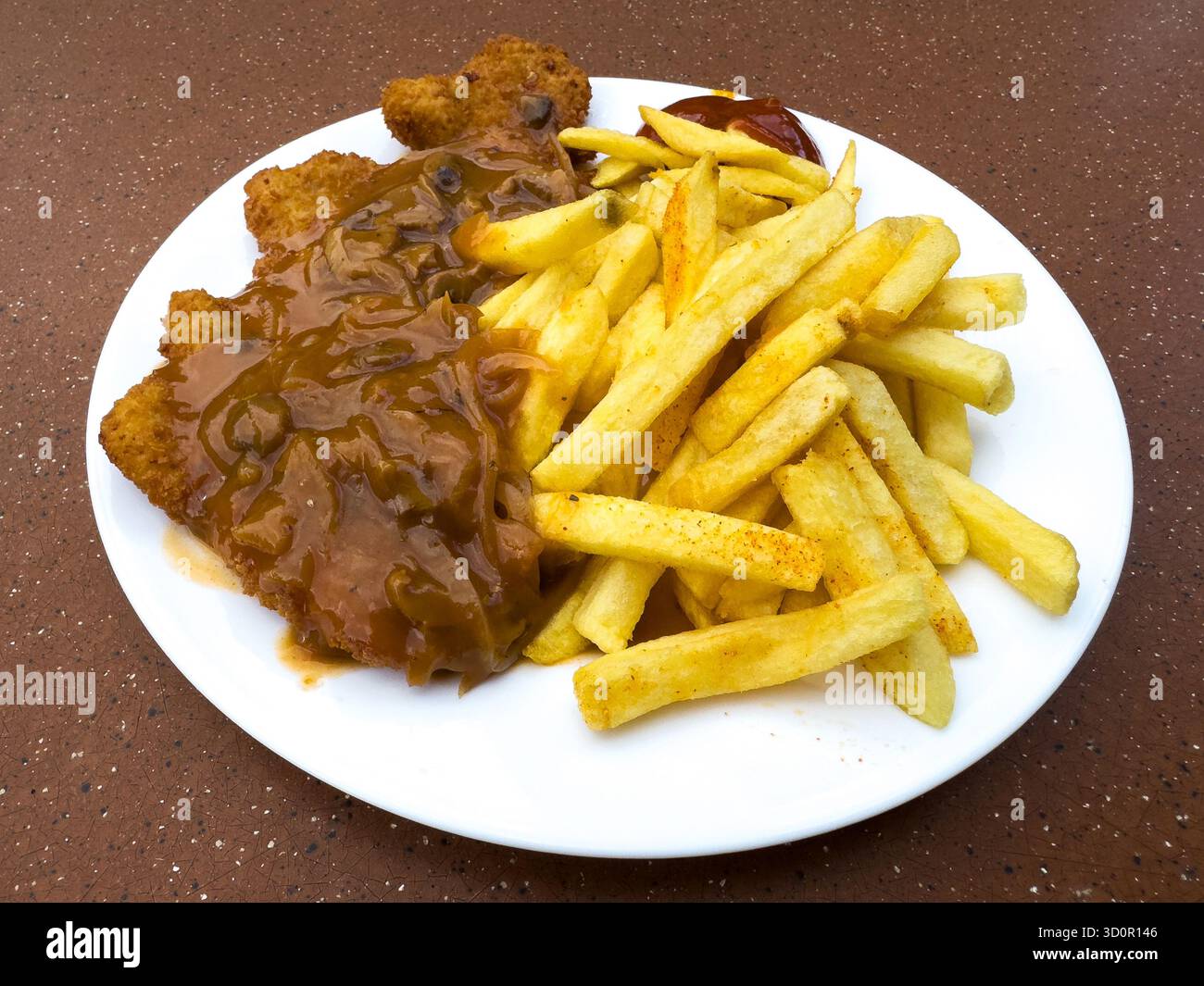 Schnitzel de porc avec une sauce aux champignons et des frites Banque D'Images